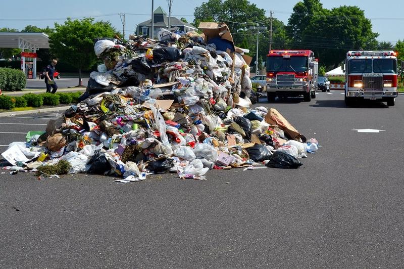 Trash truck dumps its load due to a fire in the trash pile 